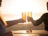 Two people sharing a pint at sunset