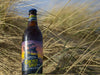 Adnams Ghost Ship 0.5% bottle in the sandy dunes
